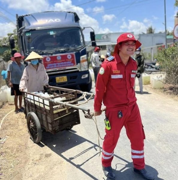 Tình nguyện viên hỗ trợ đẩy từng xe nước đến nhà cho người dân ở xa điểm tập kết của xe bồn